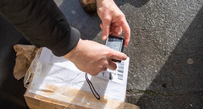 Livreur scannant une étiquette de colis