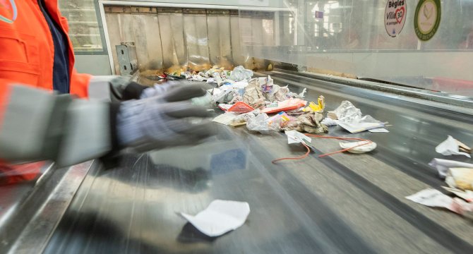 Professionnel triant les déchets recyclables sur un tapis